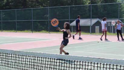 A camper playing tennis.