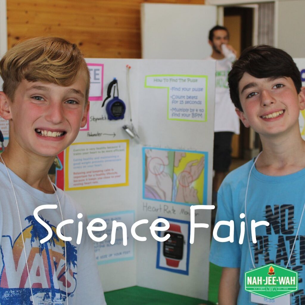 Two campers presenting at a science fair.