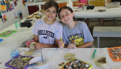 Two campers working on crafts.