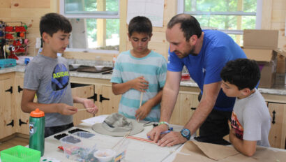 Two campers and a staff member in makerspace.