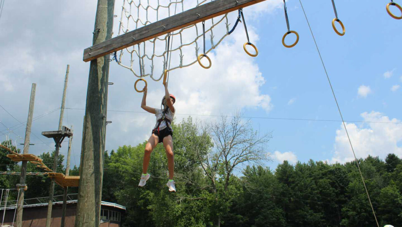 A camper doing a ropes course.