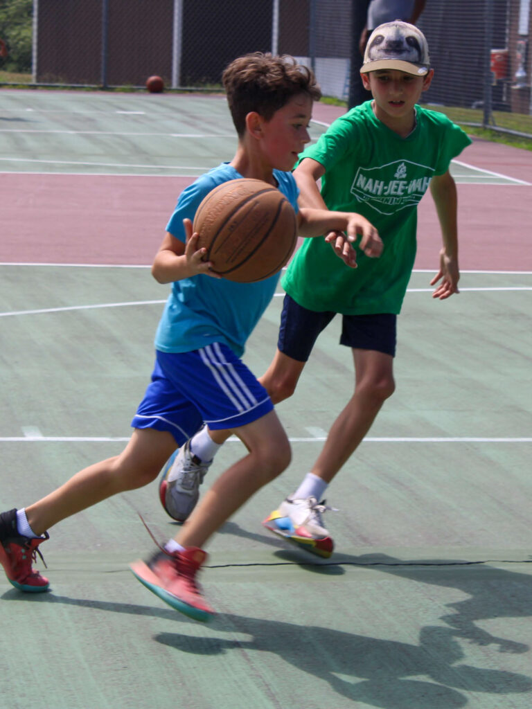 Two campers playing basketball.