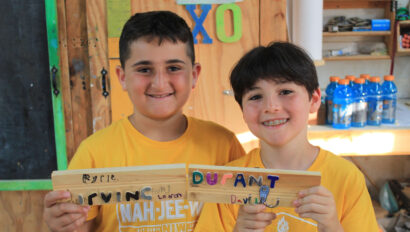 Two campers holding their projects from the woodshop.