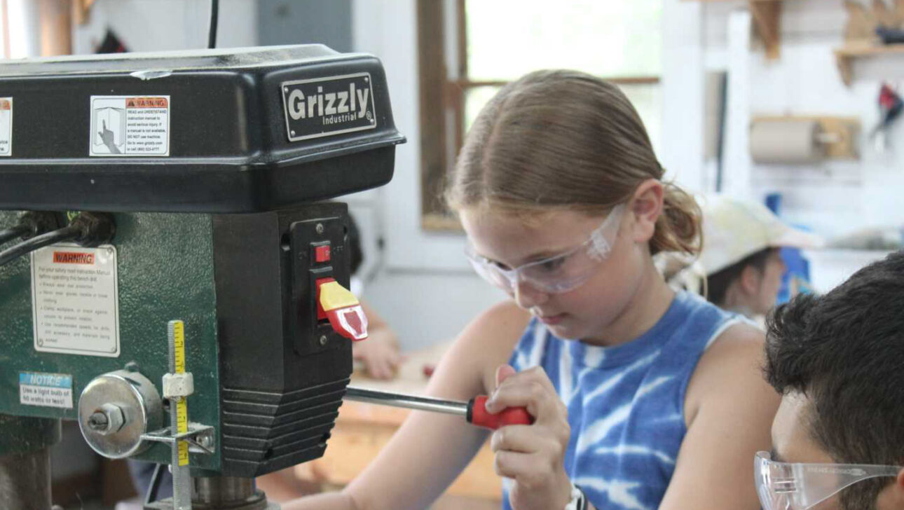 A camper working in the woodshop.