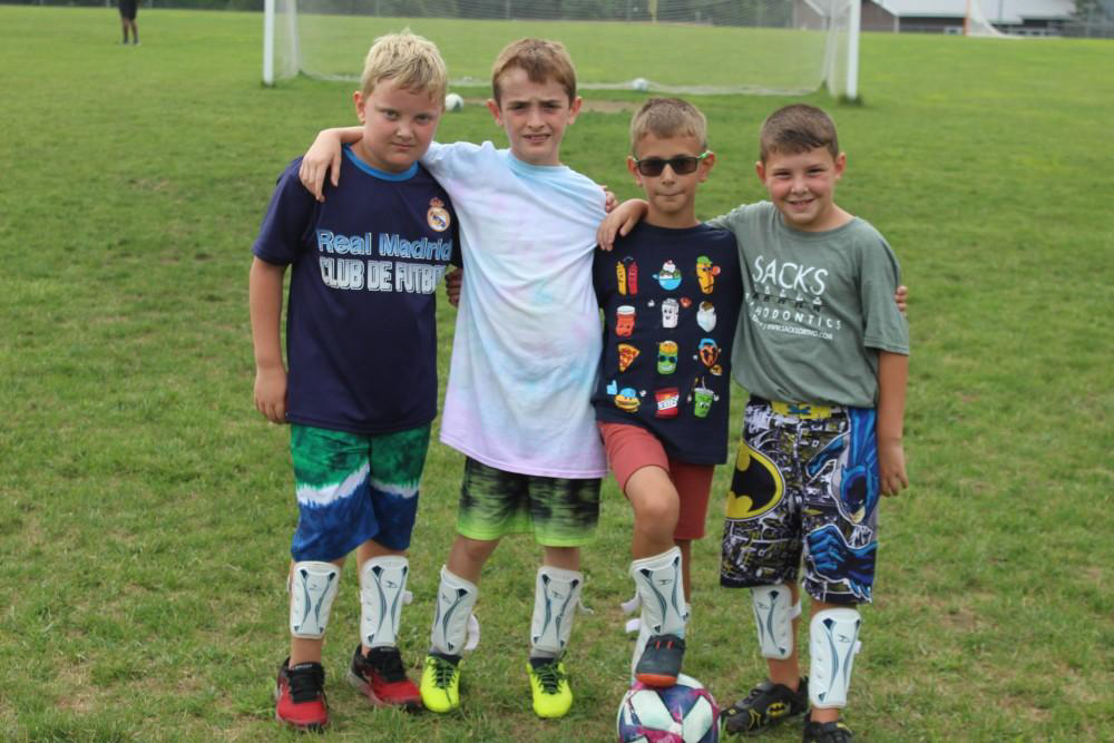 Four campers ready to play soccer.