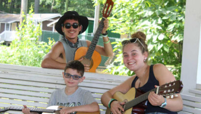 Campers learning how to play guitar.