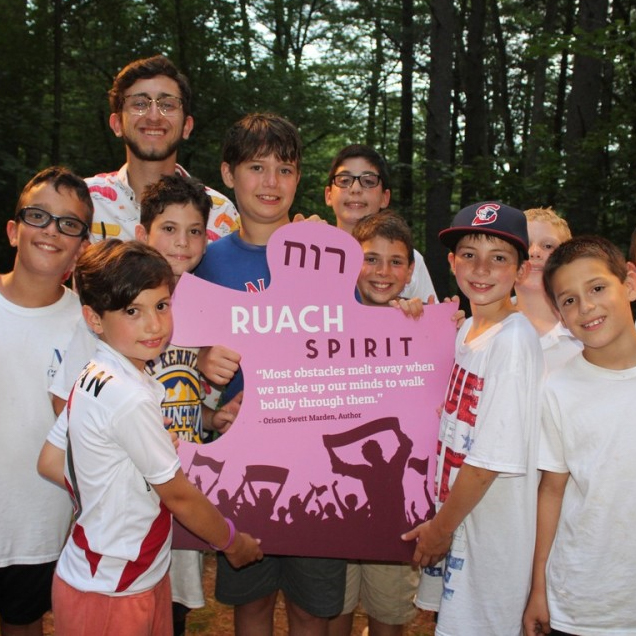 A group of campers holding up a sign that reads "Ruach Spirit".