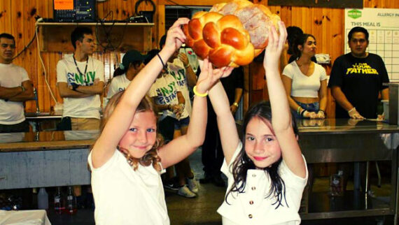 Two campers holding challah.